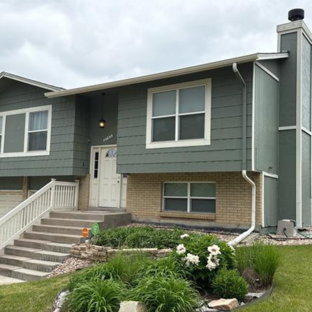 front view of residential home with aging roof and siding before storm restoration