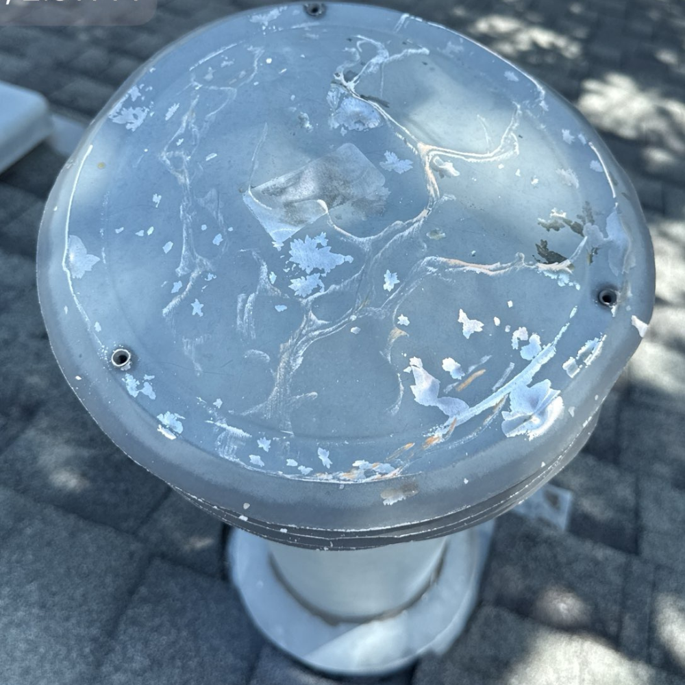 Close-up of a worn and peeling roof vent cap, showing signs of UV damage and aging that may require replacement.