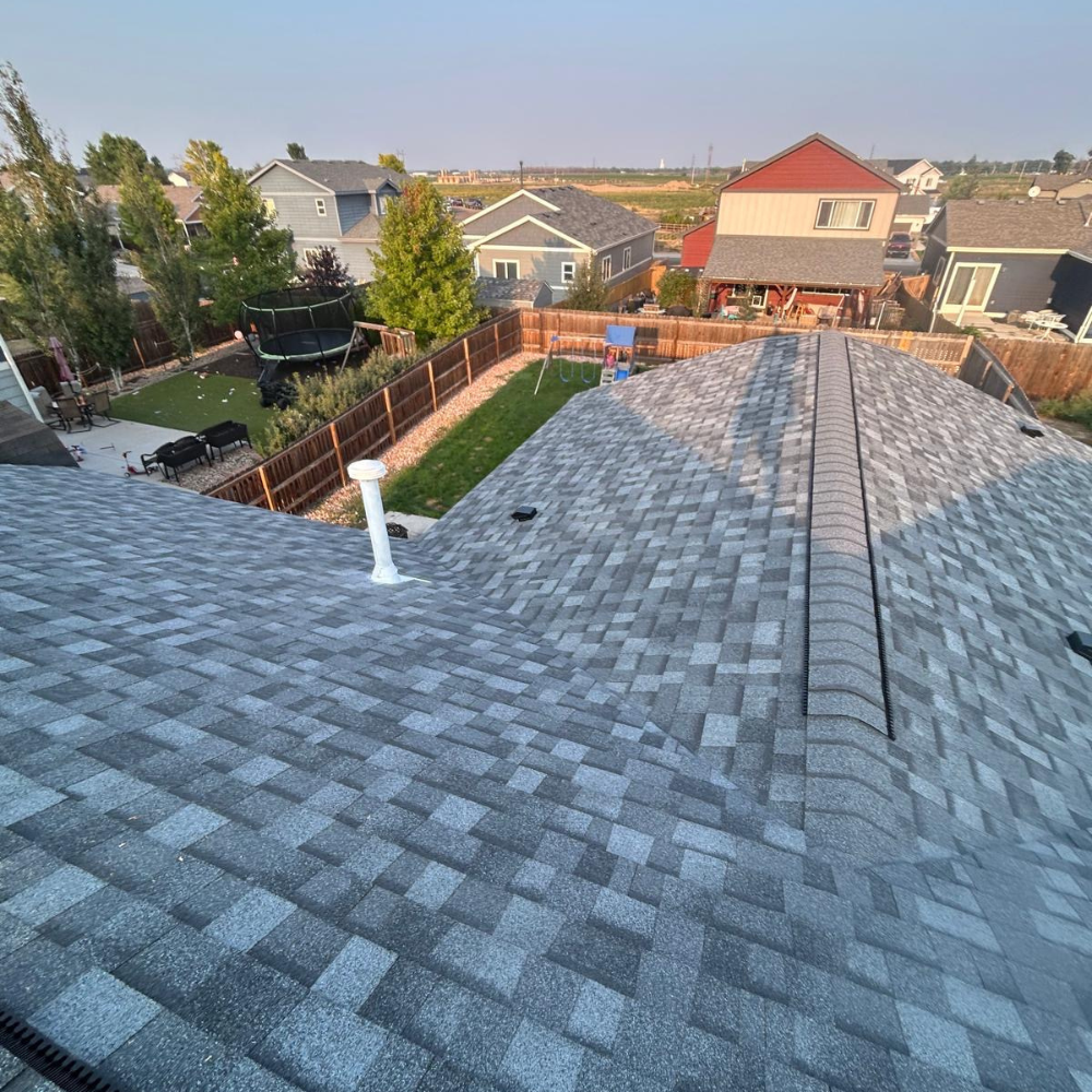 new gray asphalt shingle roof installed on residential home after storm damage replacement