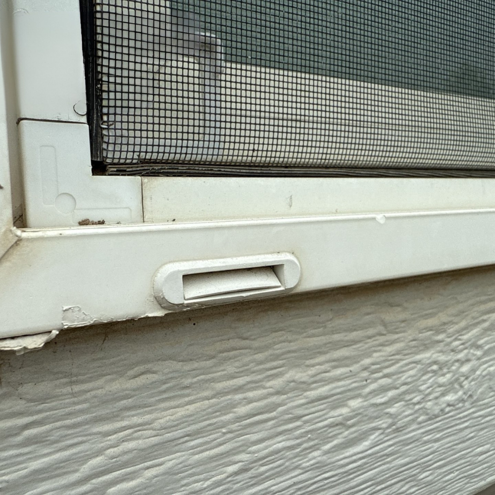 close-up of damaged window trim with peeling paint and aging exterior material