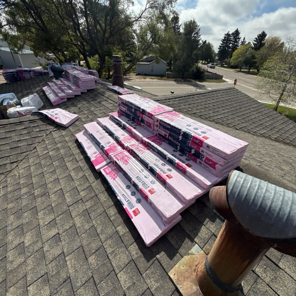 roofing shingles stacked on a rooftop for a storm damage replacement project